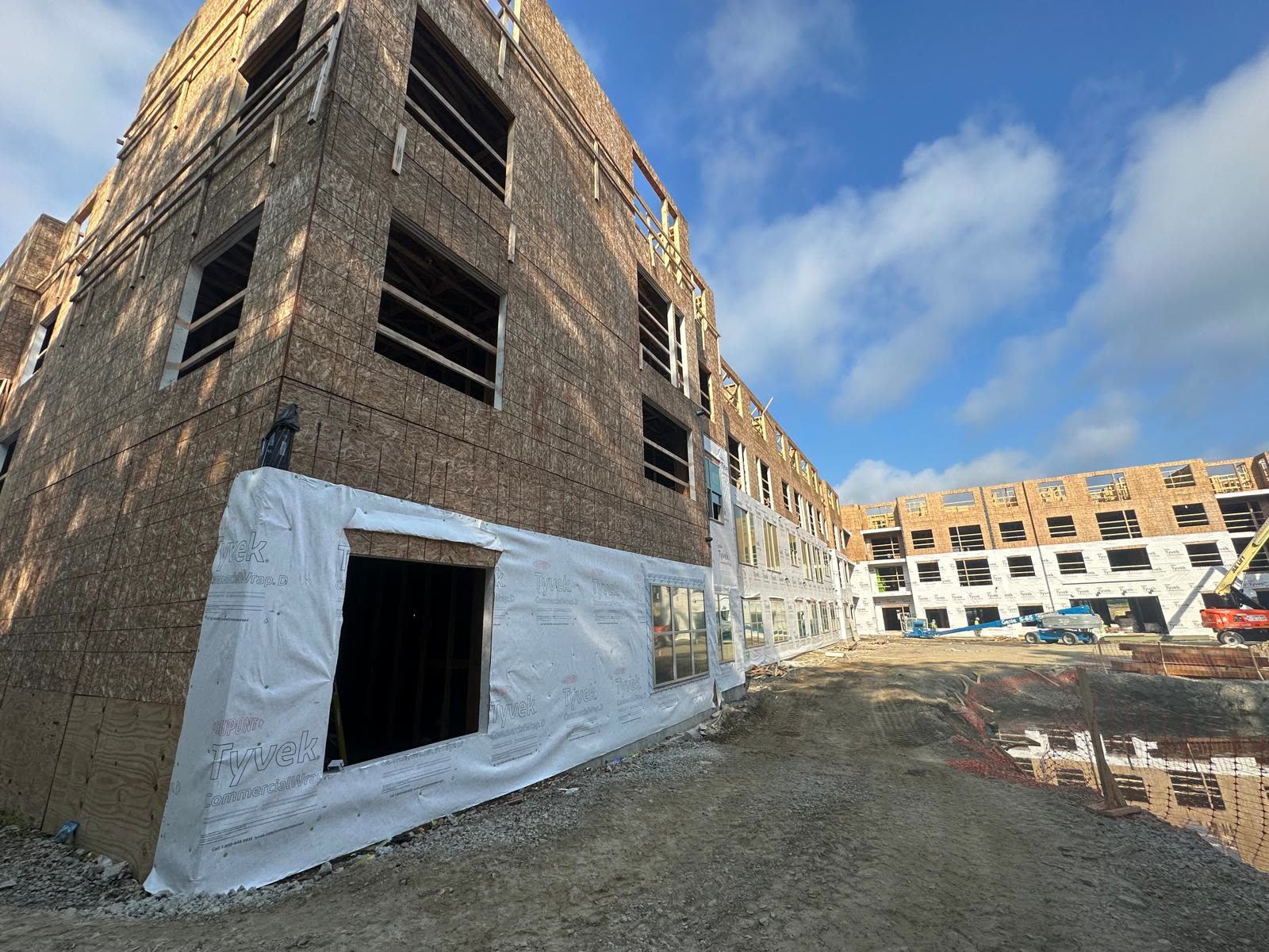 Framed building corner with housewrap starting at the lower level